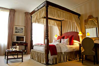 Photograph of a hotel room with four-poster bed